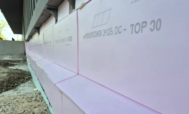 Außenwand eines Gebäudes mit montierten Dämmplatten im erdberührten Bereich als Bestandteil von Wärmedämmung und Bauwerksabdichtung.