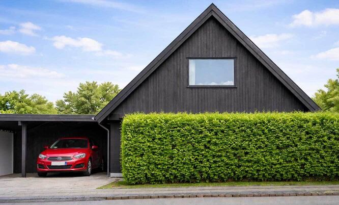 Modernes Wohnhaus mit Hecke und Garage, Darstellung eines Gebäudes für professionelle Raumluftanalyse und Schadstoffbewertung.